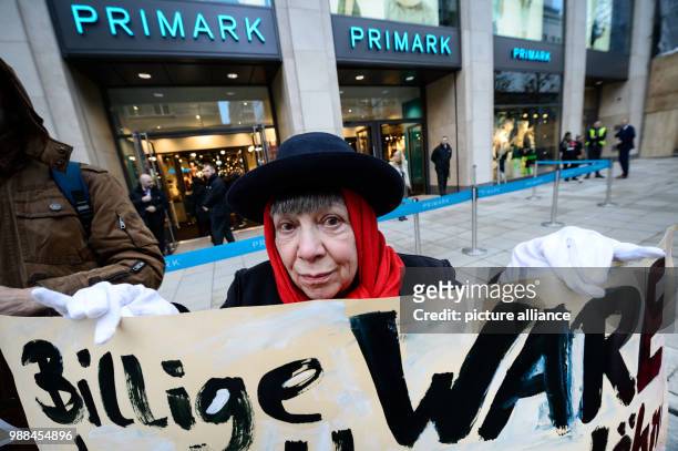 Protestor Esky Bail stands in front of the newly opened Primark shop with a sign reading "CHEAP PRODUCE" in Stuttgart, Germany, 5 December 2017. The...