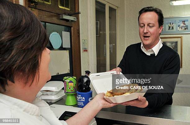 Conservative Party leader David Cameron buys food in a fish and chip shop in Long Town village, on May 4, 2010. David Cameron was in Cumbria during a...