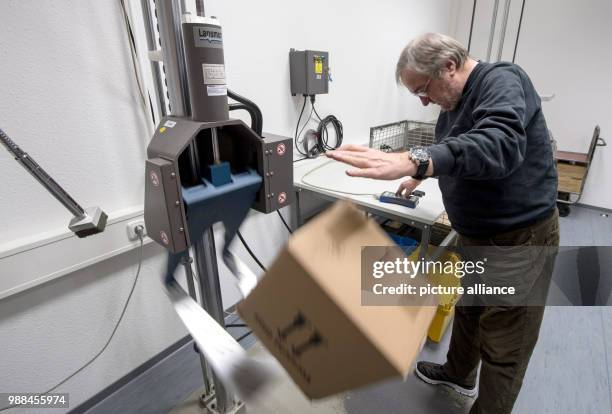 The packaging examiner Uwe Moeller testes a package by dropping it on the ground at the package check station of the German Post in Darmstadt,...