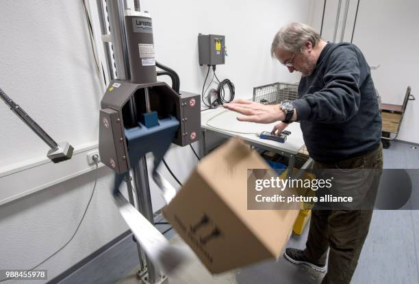 The packaging examiner Uwe Moeller testes a package by dropping it on the ground at the package check station of the German Post in Darmstadt,...