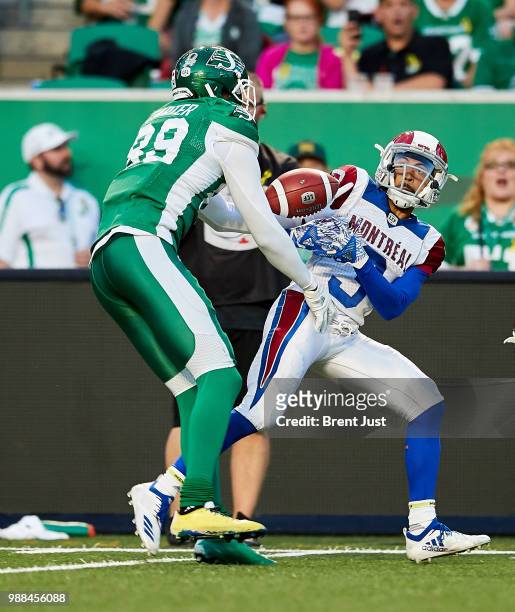 Duron Carter of the Saskatchewan Roughriders breaks up a pass intended for Chris Williams of the Montreal Alouettes in the game between the Montreal...