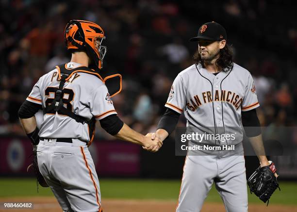 Cory Gearrin and Buster Posey of the San Francisco Giants celebrate a 7-0 win against the Arizona Diamondbacks at Chase Field on June 30, 2018 in...