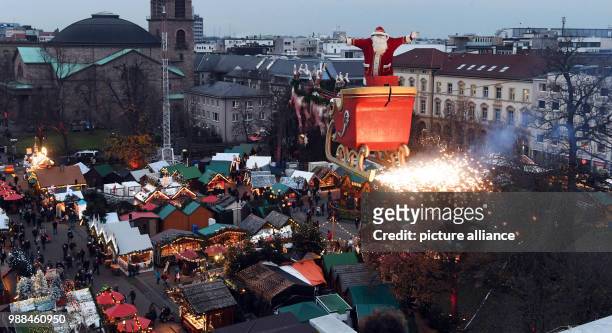 The high-wire artist Falko Traber stands in a sled dressed as Father Christmas above the Christmas market in Karlsruhe, Germany, 05 December 2017....