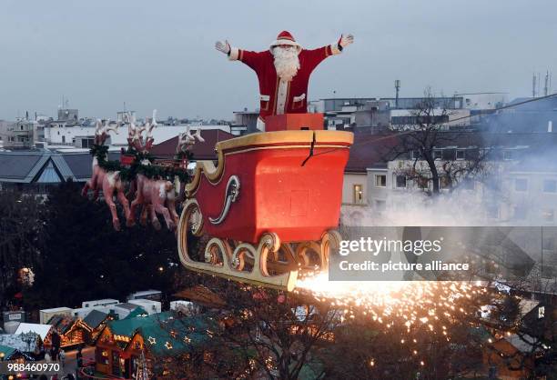 The high-wire artist Falko Traber stands in a sled dressed as Father Christmas above the Christmas market in Karlsruhe, Germany, 05 December 2017....