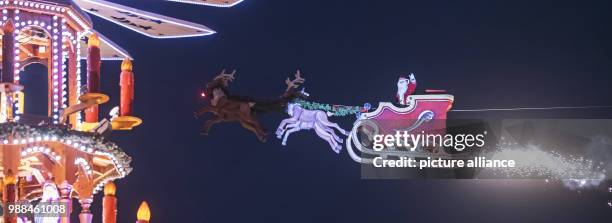 The high-wire artist Falko Traber drives in a motor-powered sled dressed as Father Christmas over the Christmas market in Karlsruhe, Germany, 05...