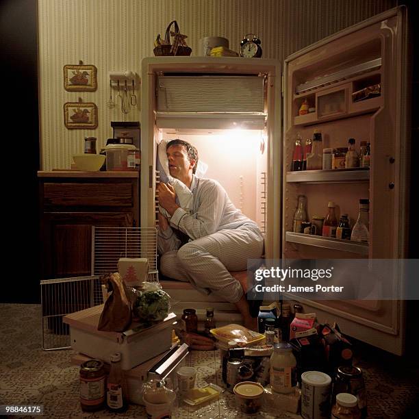man sleeping inside refrigerator - messy room stock-fotos und bilder