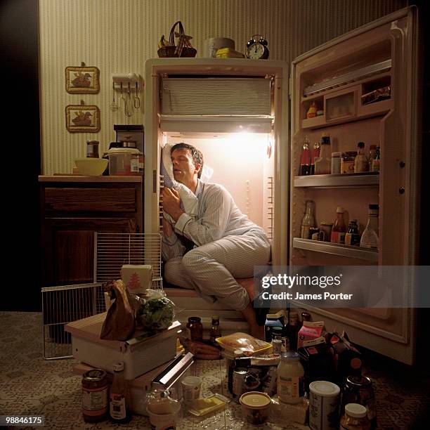 man sleeping inside refrigerator - crazy fotografías e imágenes de stock