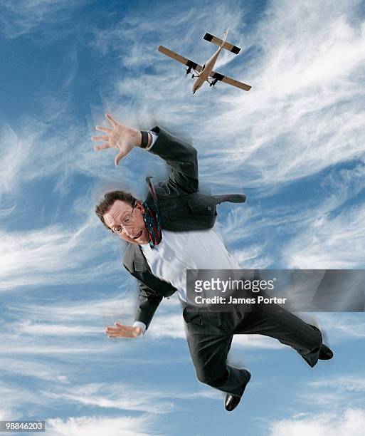 businessman falling from sky, airplane above - paracadutista foto e immagini stock