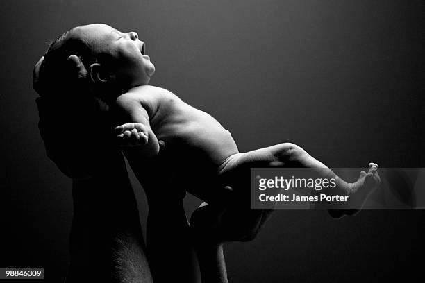 hands holding up baby - newborn ストックフォトと画像