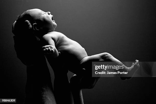 hands holding up baby - birth imagens e fotografias de stock