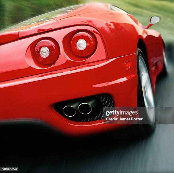 red car speeding - ferrari fotografías e imágenes de stock