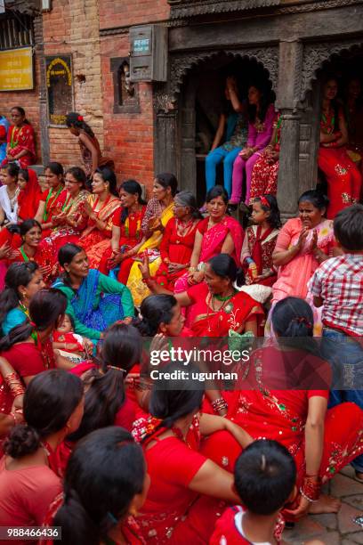 nepalese women clad in red traditional clothing on religious event in temple. - clad stock pictures, royalty-free photos & images