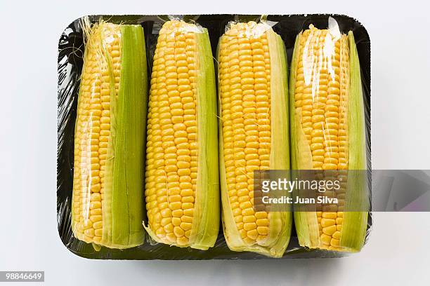 corn on the cob wrapped in plastic - ahead of the pack photos et images de collection
