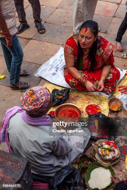 nepalese prophet and women clad in red traditional clothing on religious event in temple. - clad stock pictures, royalty-free photos & images