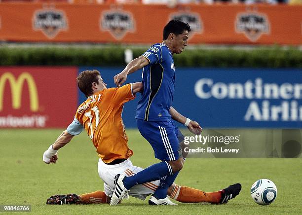 Roger Espinoza of the Kansas City Wizards fends off Andrew Hainult of the Houston Dynamo at Robertson Stadium on May 1, 2010 in Houston, Texas.