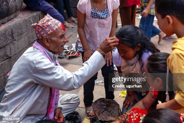 nepalese profeet en vrouwen bekleed met rode traditionele kleding op religieuze gebeurtenis in de tempel. - clad stockfoto's en -beelden