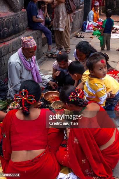 nepalese profeet en vrouwen bekleed met rode traditionele kleding op religieuze gebeurtenis in de tempel. - clad stockfoto's en -beelden