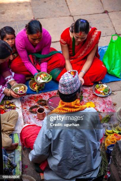 nepalese prophet and women clad in red traditional clothing on religious event in temple. - clad stock pictures, royalty-free photos & images