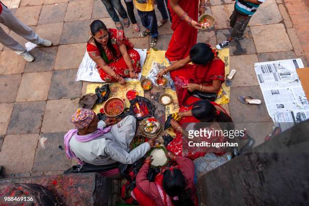 nepalese profeet en vrouwen bekleed met rode traditionele kleding op religieuze gebeurtenis in de tempel. - clad stockfoto's en -beelden