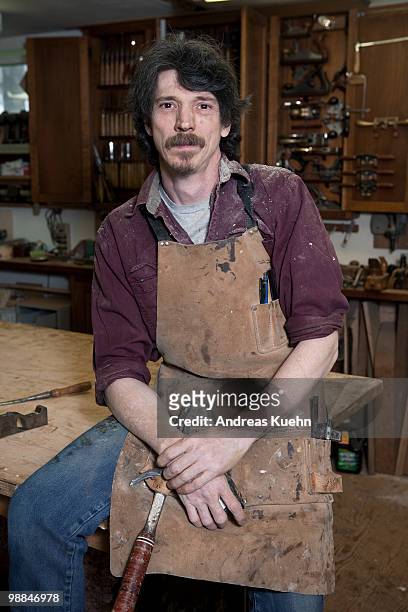 carpenter sitting on workbench, portrait. - andreas kuehn bildbanksfoton och bilder