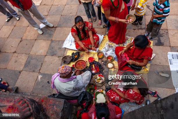 nepalese prophet and women clad in red traditional clothing on religious event in temple. - clad stock pictures, royalty-free photos & images