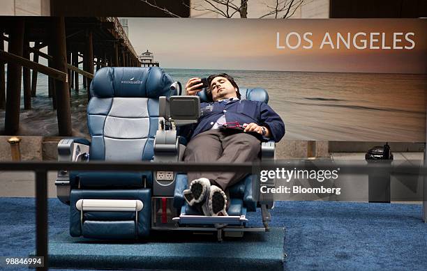 Trader sits on a mockup of Delta Air Lines Inc. Airplane seats outside of the New York Stock Exchange in New York, U.S., on Tuesday, May 4, 2010....