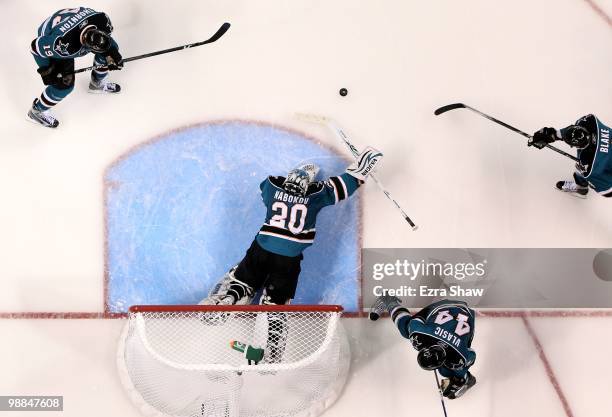 Evgeni Nabokov of the San Jose Sharks makes a save in the goal while Marc-Edouard Vlasic and Joe Thornton and Rob Blake of the Sharks play defense...