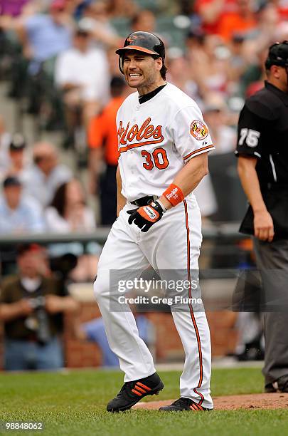 Luke Scott of the Baltimore Orioles reacts after striking out with the bases loaded in the eighth inning against the Boston Red Sox at Camden Yards...