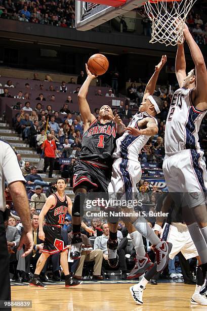 Derrick Rose of the Chicago Bulls goes up for a shot against Courtney Lee Josh Boone of the New Jersey Nets during the game at the IZOD Center on...