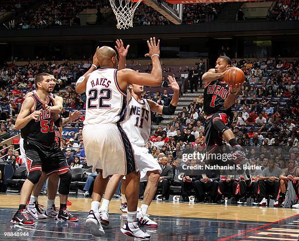 Derrick Rose of the Chicago Bulls looks to pass to teammate Brad Miller against Jarvis Hayes and Brook Lopez of the New Jersey Nets during the game...