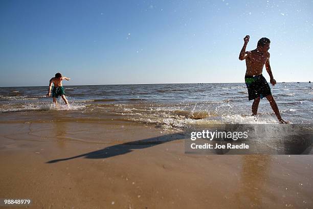 Scottie Reid and Jordan Skog enjoy the surf before the possible arrival of oil from the massive spill in the Gulf of Mexico on May 4, 2010 in...