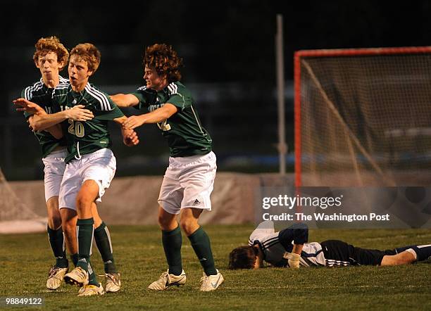 Langley's Dylan Price, left, and Alex Vorhees, right, congratulate Justin Galiani after he beat Stone Bridge keeper Nick Lowrey, behind on the...