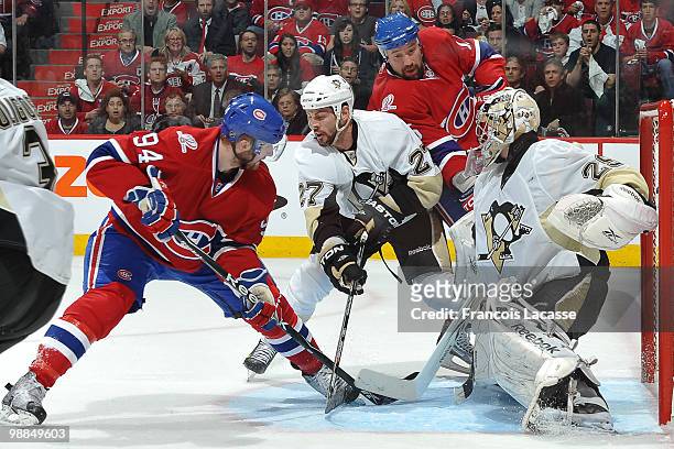 Tom Pyatt of the Montreal Canadiens battles for the puck with Craig Adams of the Pittsburgh Penguins in front of goalie Marc-Andre Fleury of the...