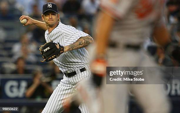 Burnett of the New York Yankees makes a throwing error on a ball hit by Cesar Izturis of the Baltimore Orioles that allowed Garrett Atkins of the...