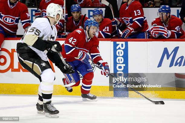 Dominic Moore of the Montreal Canadiens skates with the puck while being defended by Sergei Gonchar of the Pittsburgh Penguins in Game Three of the...