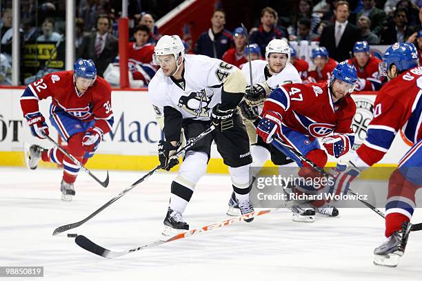 Tyler Kennedy of the Pittsburgh Penguins passes the puck while being defended by Ryan O'Byrne and Marc-Andre Bergeron of the Montreal Canadiens in...