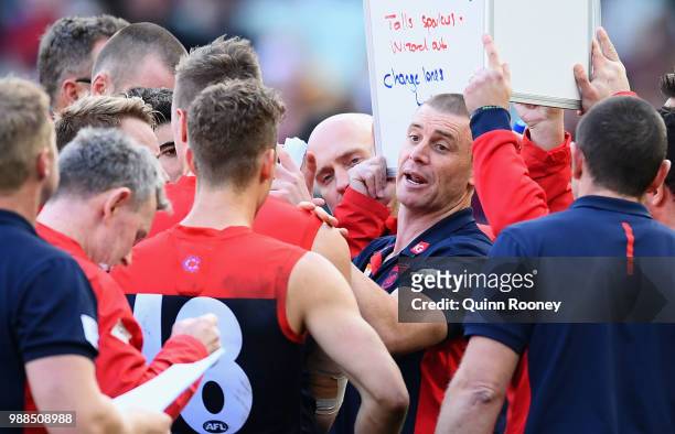 Demons head coach Simon Goodwin speaks to his players during the round 15 AFL match between the Melbourne Demons and the St Kilda Saints at Melbourne...
