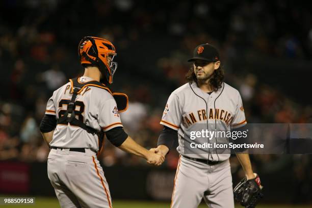 San Francisco Giants catcher Buster Posey shakes hands with San Francisco Giants relief pitcher Cory Gearrin after the final pitch during the MLB...