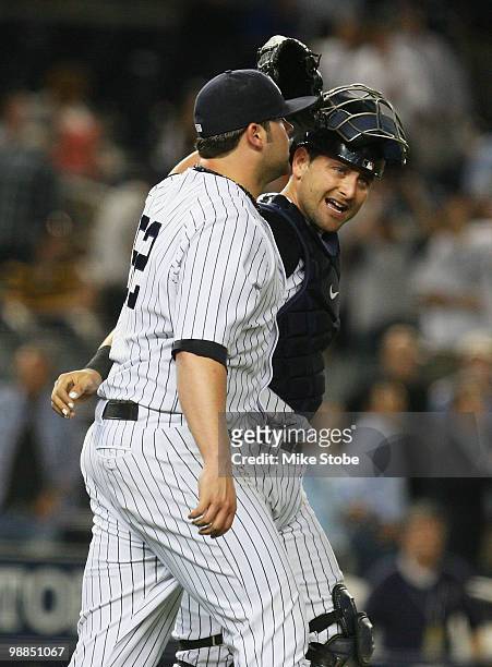 Joba Chamberlain and Francisco Cervelli of the New York Yankees congratulate each other after defeating the Baltimore Orioles 4-1 at Yankee Stadium...