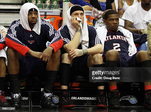 Josh Smith, Mike Bibby and Joe Johnson of the Atlanta Hawks sit on the bench and watch the fourth quarter against the Orlando Magic in Game One of...