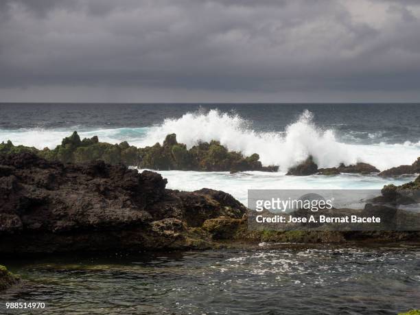 marine landscape with sky of storm, impact of the waves on the volcanic rocks of the coast in terceira island in the azores islands, portugal. - island in the sky stock pictures, royalty-free photos & images