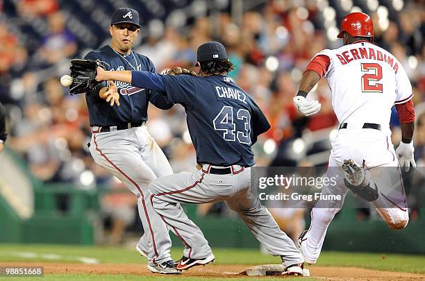 Roger Bernadina of the Washington Nationals is safe at first base ahead of the throw to Jesse Chavez and Martin Prado of the Atlanta Braves at...