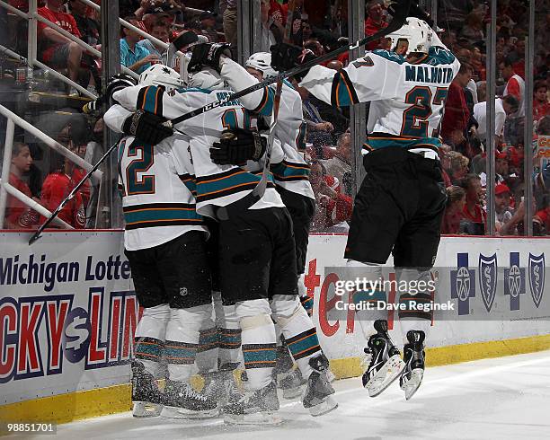 Patrick Marleau of the San Jose Sharks celebrates with teammates Joe Pavelski, Manny Malhotra and Dany Heatley after his game-winning goal on the...