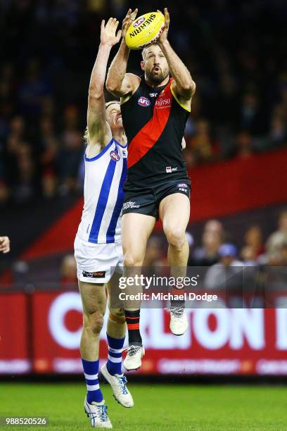 Cale Hooker of the Bombers marks the ball against Ben Brown of the Kangaroos during the round 15 AFL match between the Essendon Bombers and the North...