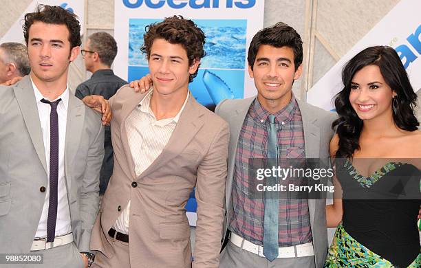 Singers Kevin Jonas, Nick Jonas and Joe Jonas of The Jonas Brothers and singer/actress Demi Lovato attend the premiere of "Oceans" at the El Capitan...