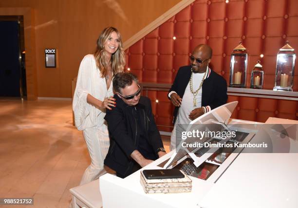 Model Heidi Klum, Niche Media and DuJour Media Jason Binn and composer, recording artist Jermaine Dupri play piano as they attend a dinner at...