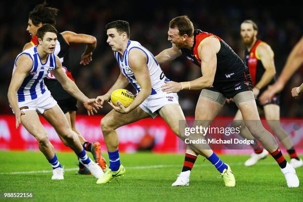 Brendon Goddard of the Bombers tackles Trent Dumont of the Kangaroos during the round 15 AFL match between the Essendon Bombers and the North...