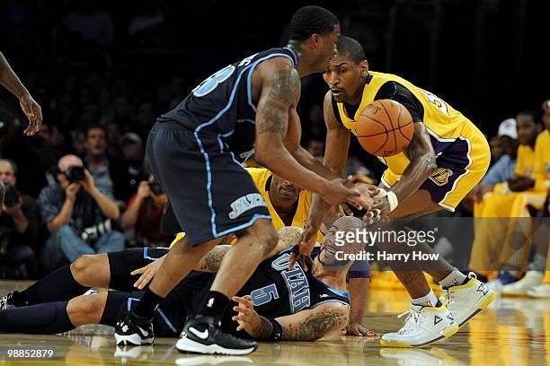 Carlos Boozer of the Utah Jazz passes the ball from the ground between Wesley Matthews of the Jazz and Ron Artest of the Los Angeles Lakers in the...