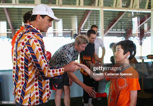 Swans coach Paul Roos meets a child with hearing difficlulties from the Sheperd Centre during a Sydney Swans AFL training session at the Sydney...