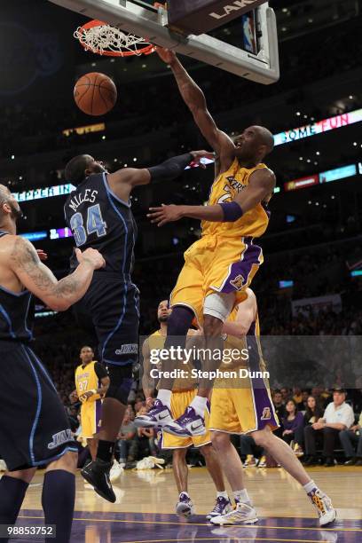 Kobe Bryant of the Los Angeles Lakers dunks over C.J. Miles of the Utah Jazz in the fourth quarter during Game Two of the Western Conference...